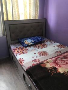 Bett in einem lila Zimmer mit Bettrahmen und Kissen in der Unterkunft Diamond Home Stay - Private Rooms in Kathmandu