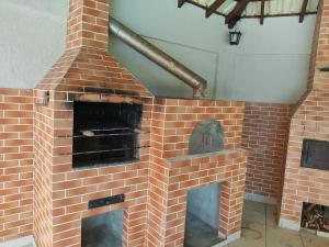 um forno de tijolos com uma porta aberta em Casa de campo em São José dos Pinhais