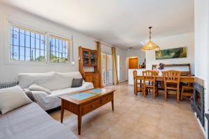 a living room with a couch and a table at Villa Alpamar in Les tres Cales