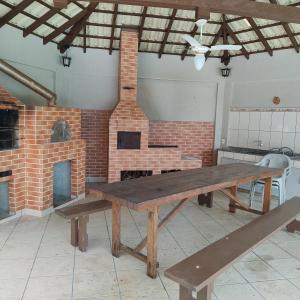 uma mesa de piquenique em frente a um forno de tijolos em Casa de campo em São José dos Pinhais