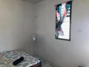 a bedroom with a bed and a window and a fan at Payag in El Nido