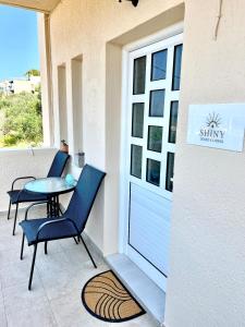 een patio met 2 stoelen, een tafel en een raam bij “Shiny” sea view apartment at Istron in Agios Nikolaos