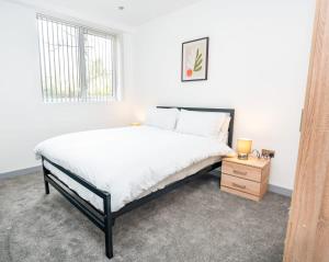 a white bedroom with a large bed and a window at Bright and Modern 1 Bed Apartment in Redditch in Redditch