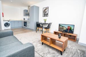 a living room with a couch and a tv at Bright and Modern 1 Bed Apartment in Redditch in Redditch