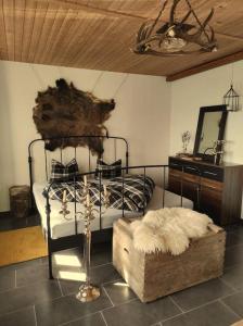 ein Schlafzimmer mit einem Metallbett und einer Holzdecke in der Unterkunft Ferienhaus Bergträumli (Keine direkte Zufahrt) in Gommiswald