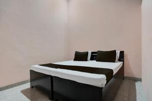 Una cama en blanco y negro en una habitación en SPOT ON guest house en Bulandshahr