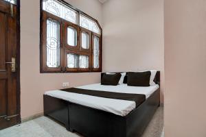Cama grande en habitación con ventana en SPOT ON guest house en Bulandshahr
