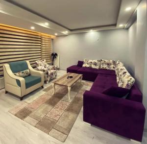 a living room with a purple couch and a coffee table at Tk Kurdal Suit in Samsun