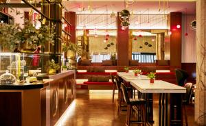 a restaurant with a bar with tables and chairs at Hyatt Centric Gran Via Madrid in Madrid