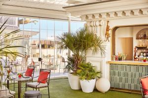 a patio with chairs and plants and a bar at Hyatt Centric Gran Via Madrid in Madrid