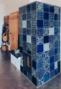 uma parede de azulejos azuis com uma lareira num quarto em Kellerstöckl am Berg em Eisenberg an der Pinka