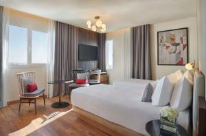 a hotel room with a large bed and a desk at Hyatt Centric Gran Via Madrid in Madrid