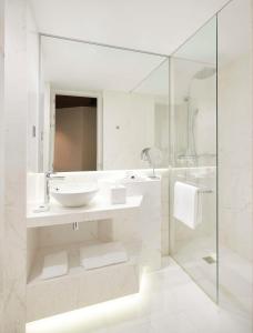 a white bathroom with a sink and a shower at Hyatt Centric Gran Via Madrid in Madrid