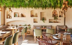 a restaurant with tables and chairs and plants on the wall at Hyatt Centric Gran Via Madrid in Madrid