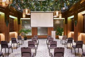 een conferentieruimte met stoelen en een projectiescherm bij Hyatt Centric Gran Via Madrid in Madrid
