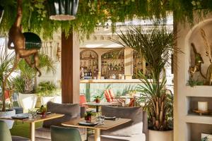 a restaurant with tables and chairs and plants at Hyatt Centric Gran Via Madrid in Madrid