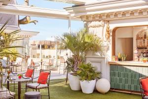 an outdoor patio with chairs and tables and plants at Hyatt Centric Gran Via Madrid in Madrid