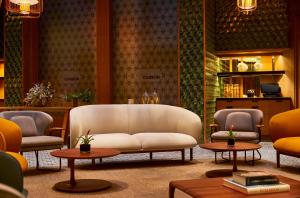a living room with a white couch and two tables at Hyatt Centric Gran Via Madrid in Madrid