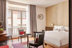 a hotel room with a bed and a table and chairs at Hyatt Centric Gran Via Madrid in Madrid