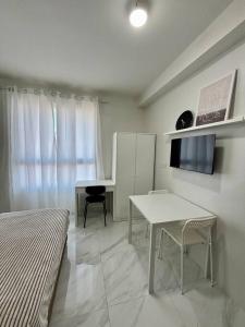 a bedroom with a desk and a table and a table and chair at Casa Mira Guadalupe by Leera's Condo in Cebu City