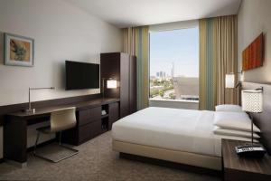 a hotel room with a bed and a desk and a window at Hyatt Place Riyadh Sulaimania in Riyadh