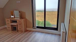 an empty room with a desk and a large window at M033 Achill Gatehouse By The Greenway in Westport
