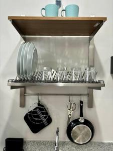 a shelf with glasses and utensils on it at Casa Mira Guadalupe by Leera's Condo in Cebu City