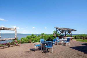a patio with chairs and tables and a view of the ocean at AmericInn by Wyndham Ashland in Ashland