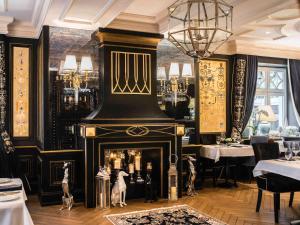 ein Esszimmer mit Kamin in einem Restaurant in der Unterkunft Bachleda Luxury Hotel Krakow MGallery Hotel Collection in Krakau