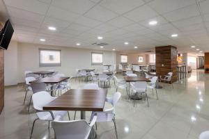une cafétéria avec des tables et des chaises dans un bâtiment dans l'établissement Sleep Inn Mexicali, à Mexicali