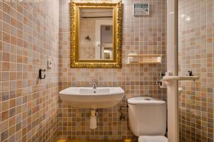a bathroom with a sink and a toilet and a mirror at Encanto en Las Ramblas: Espacio perfecto para 9 in Barcelona