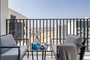 a balcony with two chairs and a table with a vase at Frank Porter - The Nook 2 in Dubai