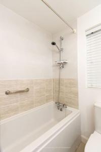 a white bathroom with a tub and a toilet at Cosy Home in Picturesque Village Cottingham in Cottingham