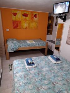 a room with two beds and a tv on a wall at BBrezza Marina in Stintino