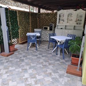 a patio with tables and chairs on a tiled floor at BBrezza Marina in Stintino