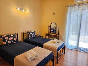 イプソスにあるStamatis Family Apartmentのベッド2台と鏡のある寝室