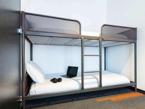 - un lit superposé avec un ordinateur portable dans l'établissement greet Hotel Nancy Sud, à Houdemont