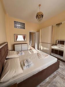 een groot wit bed in een slaapkamer met een kroonluchter bij Tirana Dry Lake Flat in Sauk