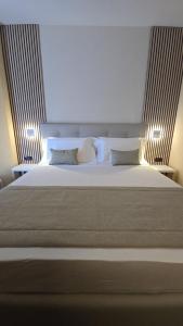 a bedroom with a large white bed with two lights at Parc Hotel in Poppi