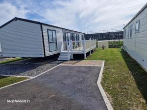 a tiny house with a porch next to a building at Beachwood 21 in Camber