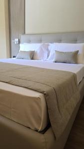 a large bed with white sheets and pillows at Parc Hotel in Poppi