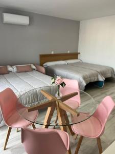 um quarto com uma mesa de vidro e 2 camas em Apartamentos Antequera em Antequera