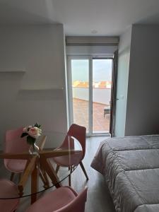 a bedroom with a glass table and chairs and a bed at Apartamentos Antequera in Antequera