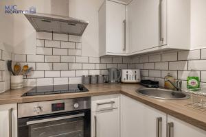 a kitchen with a sink and a stove top oven at Riverside in Hawick
