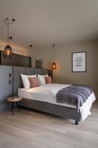 1 dormitorio con 1 cama grande y 1 mesa en Belia Lofts - ADULTS ONLY, en Appiano sulla Strada del Vino