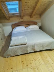 uma cama grande num quarto com piso em madeira em Runjini dvori em Kukljica