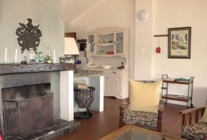 a living room with a fireplace and a kitchen at Schaefers' Halt in Dullstroom