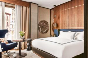 a hotel room with a bed and a chair at Thompson Madrid, by Hyatt in Madrid