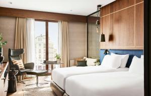 um quarto de hotel com uma cama grande e uma janela em Thompson Madrid, by Hyatt em Madrid