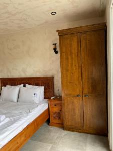 a bedroom with a bed and a wooden cabinet at MAVİ AT HOTEL Blue Horse in Gümüşdere